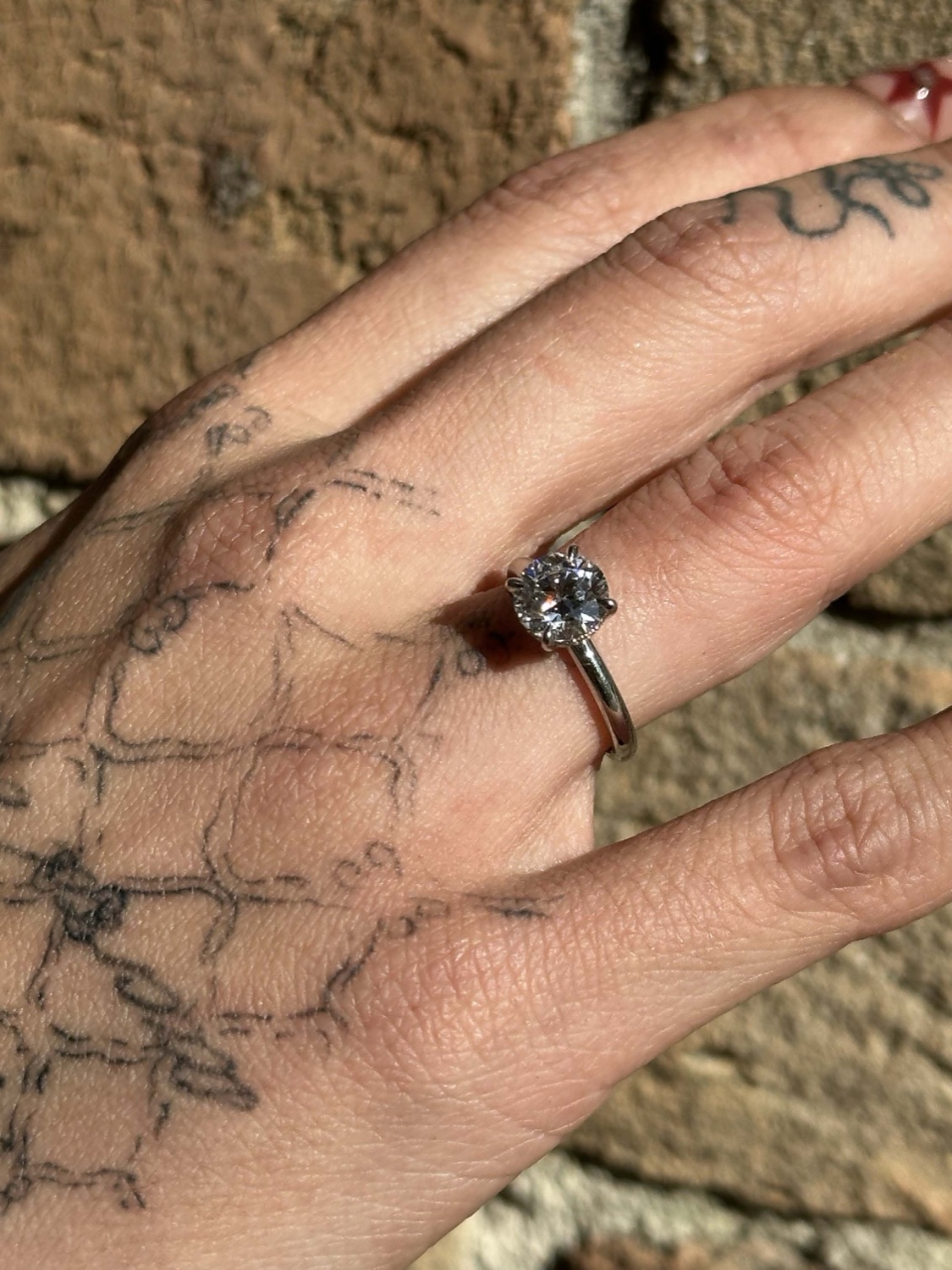 A diamond engagement ring in platinum, lifted on a hidden halo, worn on a hand