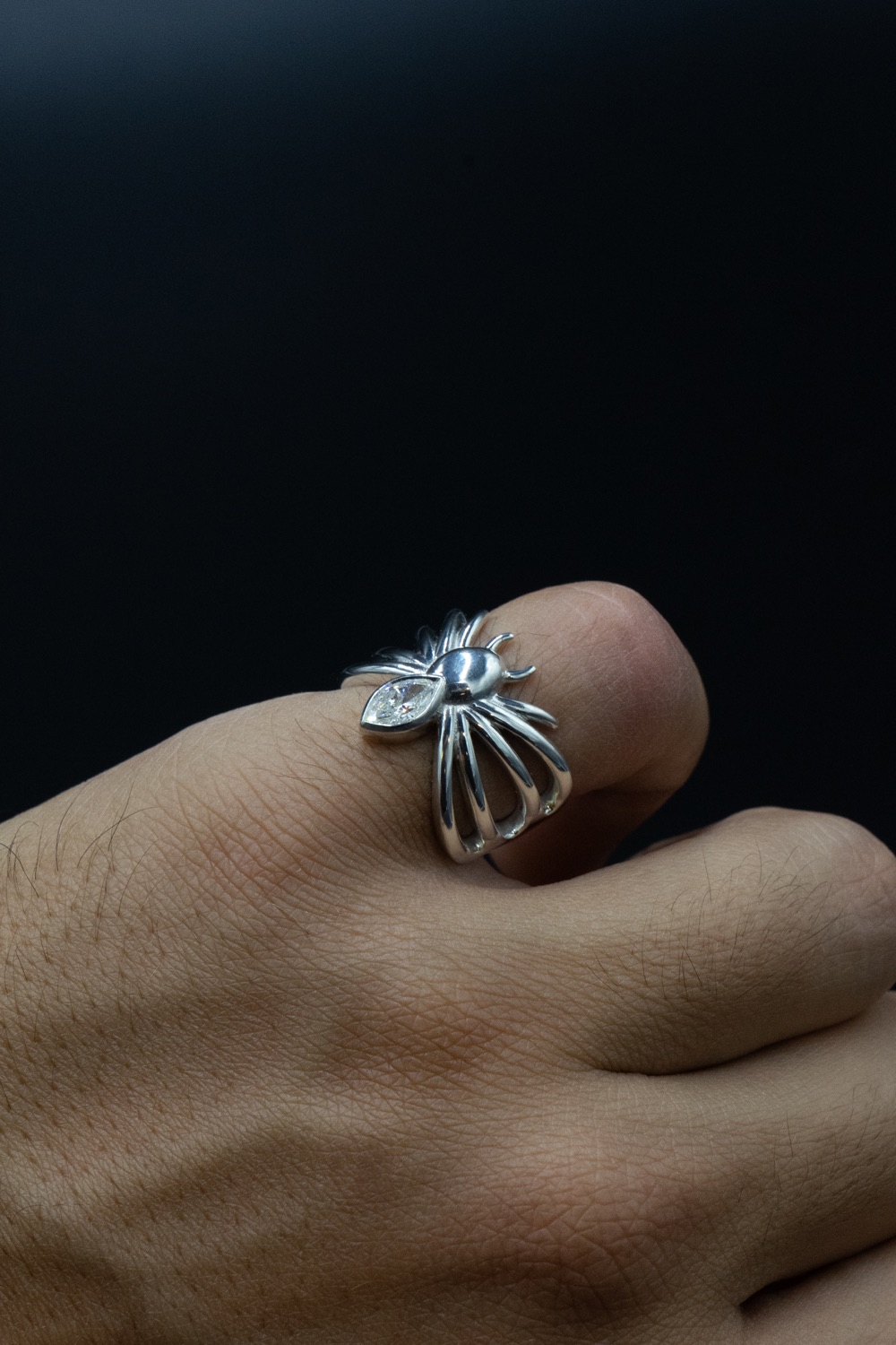 The Spider Ring worn on a hand, a marquise diamond set in fine drawn silver claws